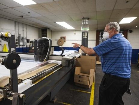 Industrial Polymers and Chemicals Chief Technical Officer Tom Kennedy with the company’s CNC Cutter tasked to outline and cut PPE gowns.